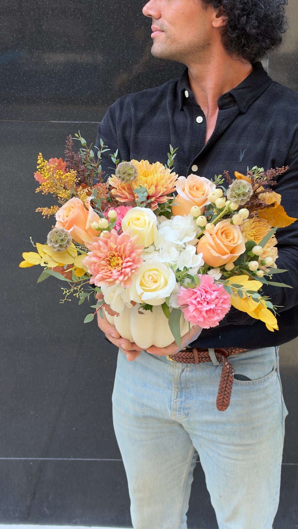 Arcadia Autumn fall arrangement with roses, dahlias, pink carnations and scabiosa pods in a white ceramic pumpkin