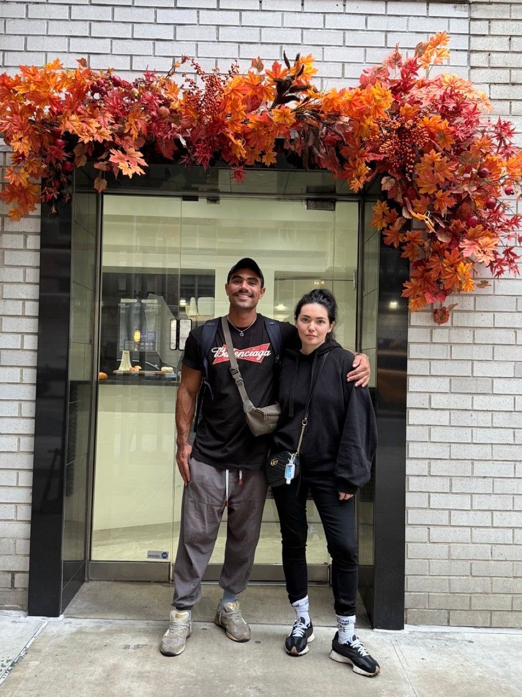 Novapetal cofounders Olga and Anthony Sheppard outside the Manhattan shop under an autumn installation of orange and red foliage over the door