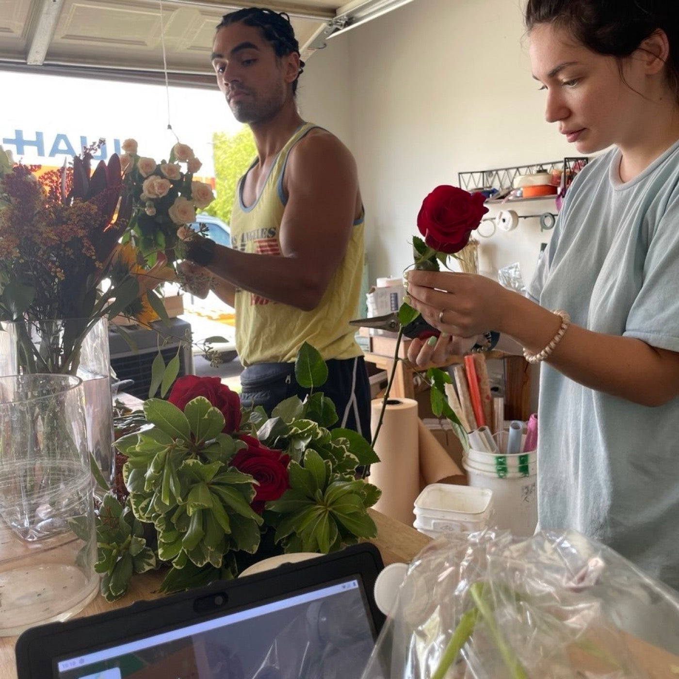 Olga and Anthony Sheppard making arrangements in the garage where Novapetal started in Phoenix in 2021, the garage door open behind them