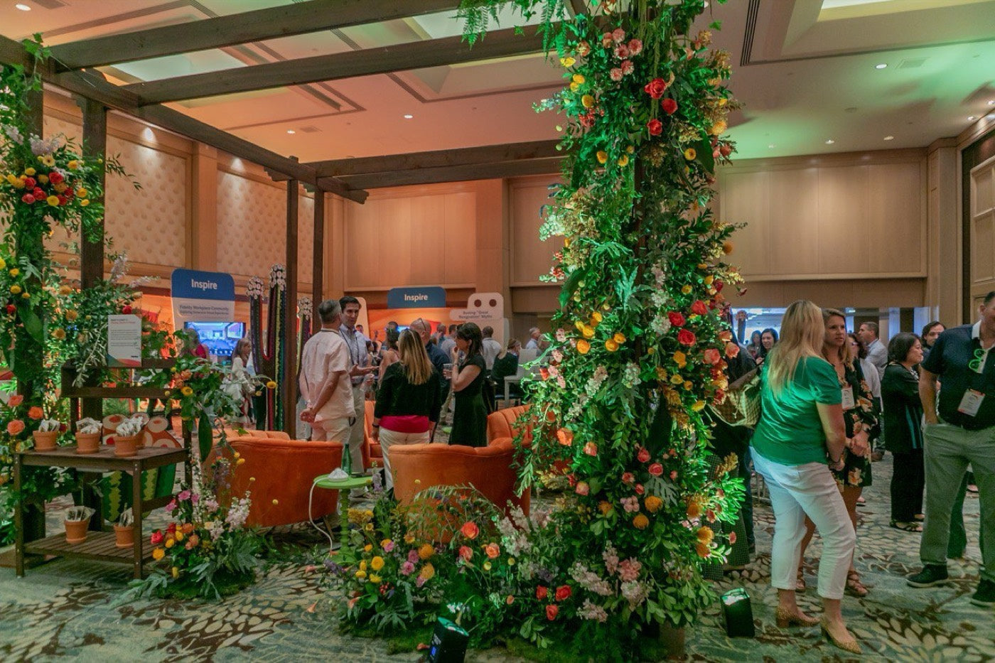 Floral columns and a lounge set built by Novapetal Flower Lab for a Fidelity corporate event in a Phoenix hotel ballroom, wrapped in greenery, citrus and roses
