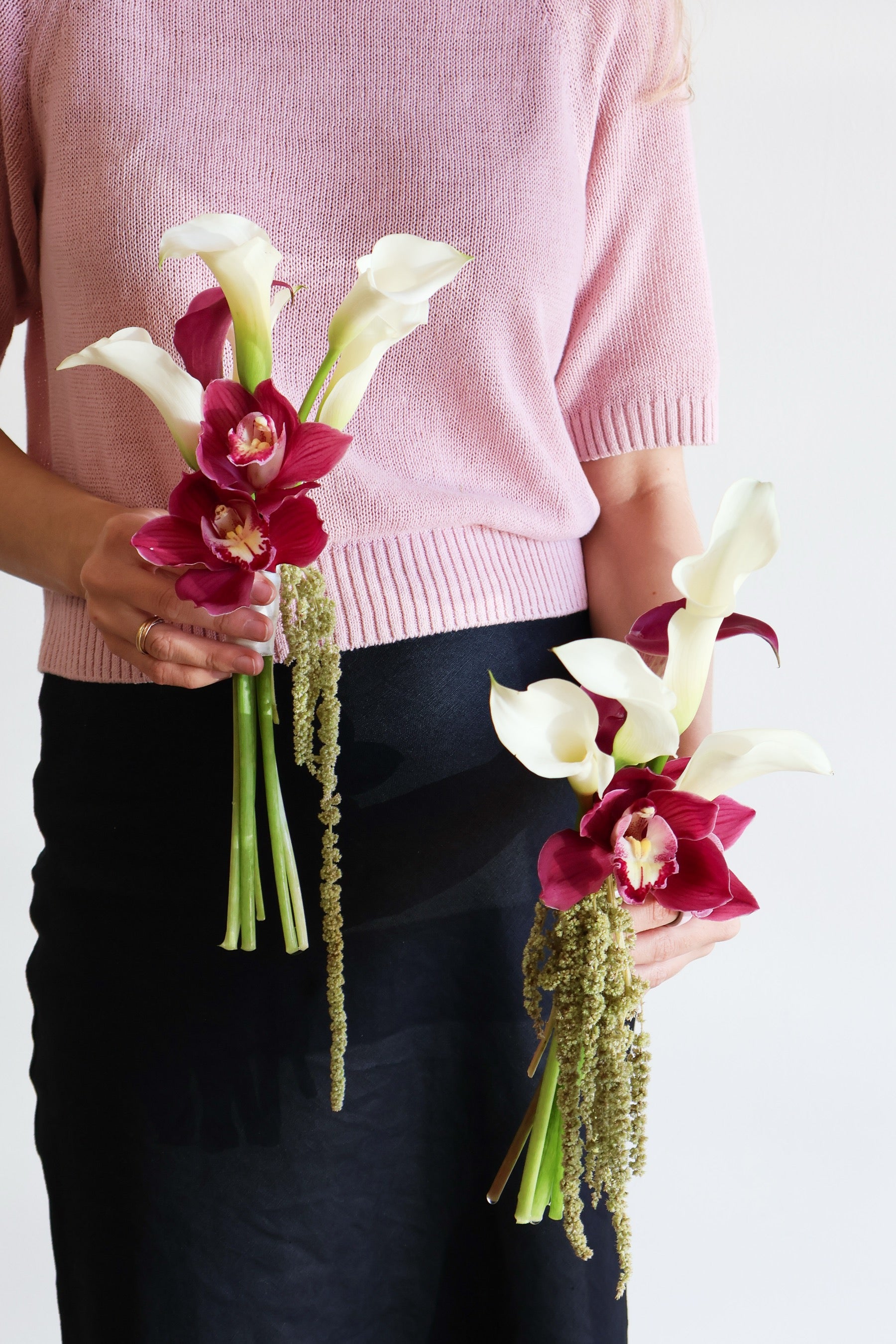 Two small bouquets by Novapetal Flower Lab of white calla lilies, burgundy cymbidium orchids and hanging green amaranthus