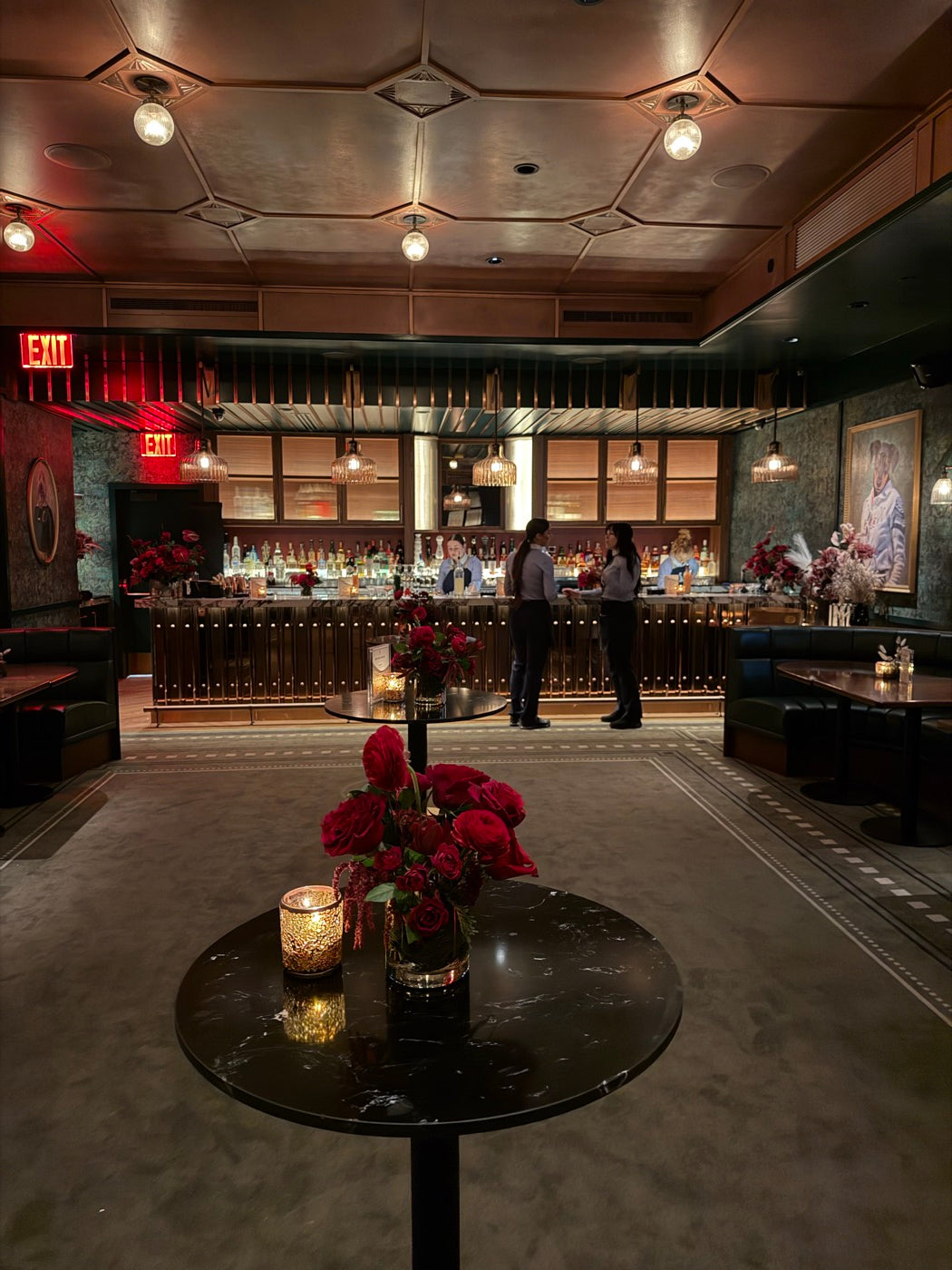 The room at the same red event, with rose arrangements by Novapetal Flower Lab on every cocktail table and along the bar