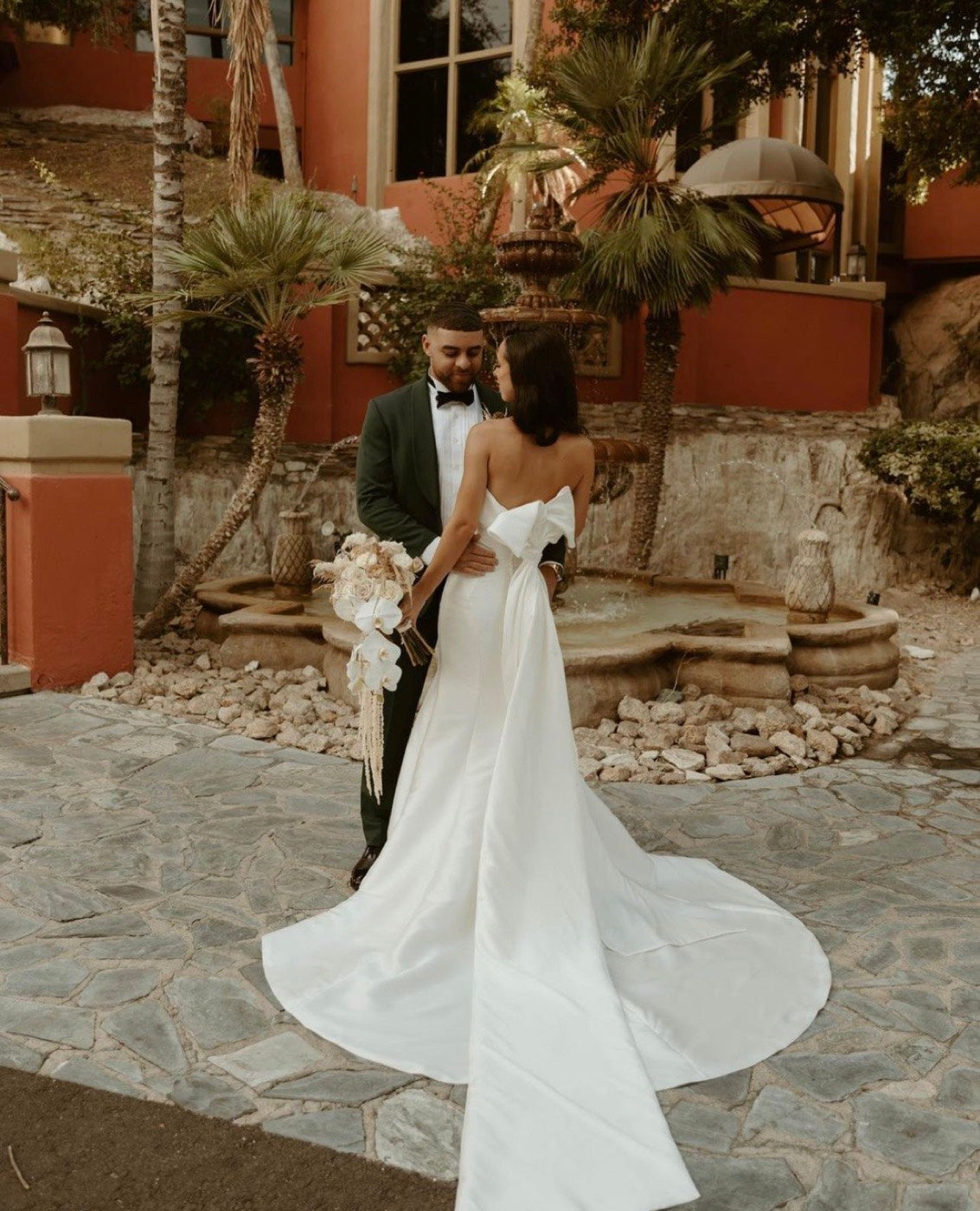 Bride and groom outside a Phoenix resort, the bride holding a white and dried-grass bouquet by Novapetal Flower Lab