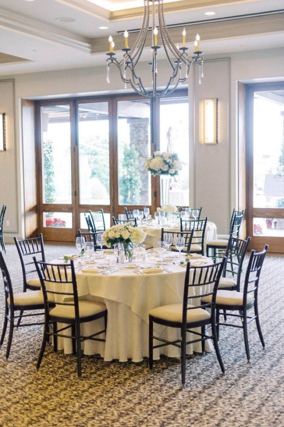 Head table by Novapetal Flower Lab with a trailing greenery garland and rows of candles along the linen